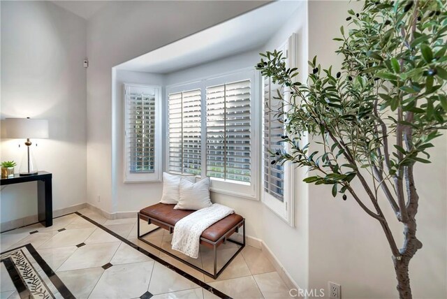 sitting room with baseboards and light tile patterned floors