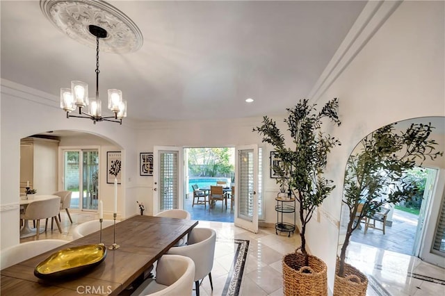 dining room with arched walkways, crown molding, recessed lighting, and an inviting chandelier