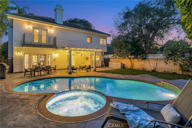 view of swimming pool with a pool with connected hot tub, french doors, a patio, and fence