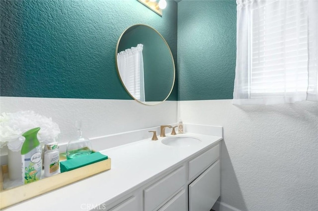 bathroom with vanity and a textured wall