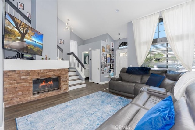 living room featuring stairs, high vaulted ceiling, a fireplace, and dark wood finished floors