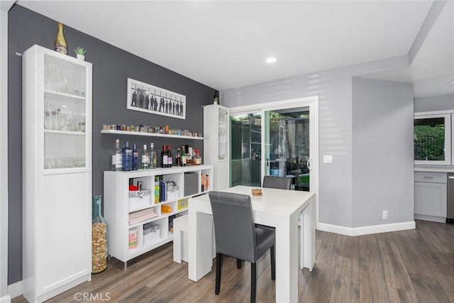 dining space with a healthy amount of sunlight, dark wood finished floors, and baseboards