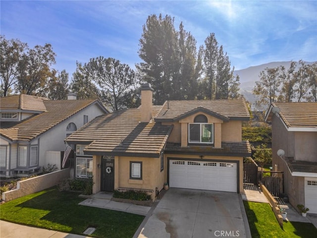 view of front of house featuring a mountain view, a garage, driveway, stucco siding, and a chimney