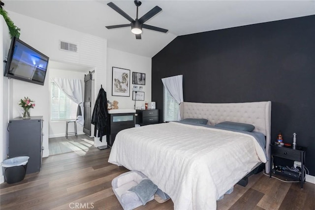 bedroom featuring dark wood-type flooring, lofted ceiling, visible vents, and baseboards