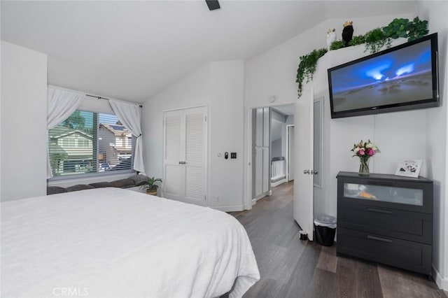 bedroom with ceiling fan, dark wood-type flooring, baseboards, vaulted ceiling, and a closet