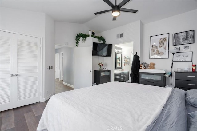 bedroom with ceiling fan, dark wood-style flooring, visible vents, vaulted ceiling, and a closet