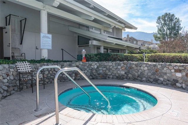 view of swimming pool with a hot tub and a mountain view