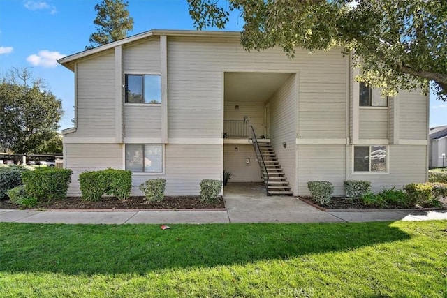 view of front of home featuring a front yard and stairs