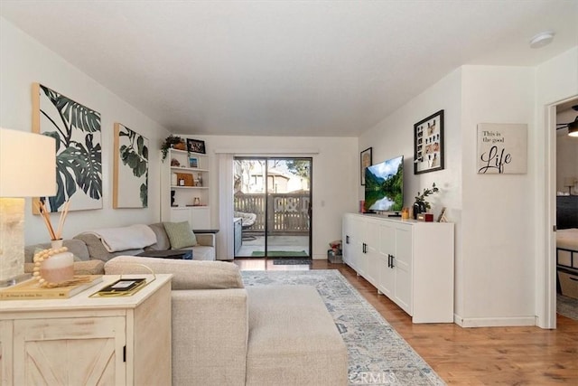 living area featuring light wood finished floors and baseboards