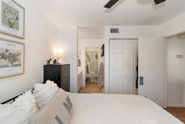 bedroom featuring a closet, visible vents, ceiling fan, and ensuite bathroom