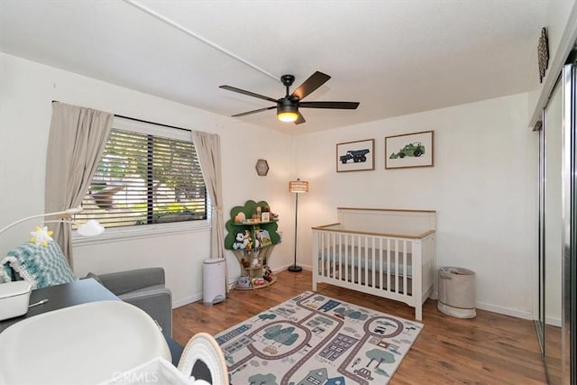 bedroom with wood finished floors, a ceiling fan, and baseboards