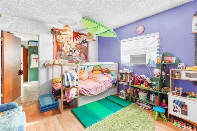 bedroom with light wood-type flooring and a textured ceiling