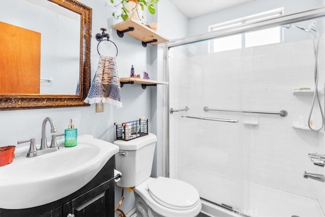 full bath featuring toilet, a stall shower, and vanity