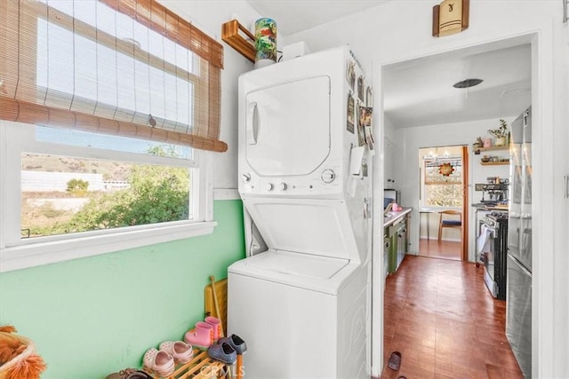 clothes washing area with stacked washer / dryer and laundry area