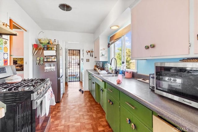 kitchen featuring stainless steel appliances, a toaster, a sink, and green cabinetry