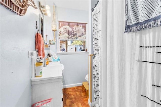 full bathroom with a sink, toilet, and baseboards