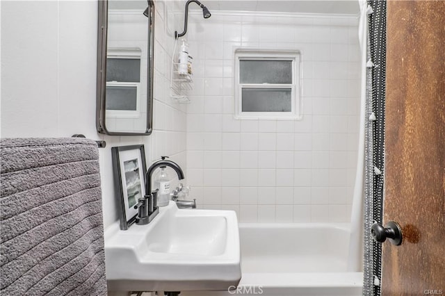 full bathroom with shower / bath combination with curtain and a sink