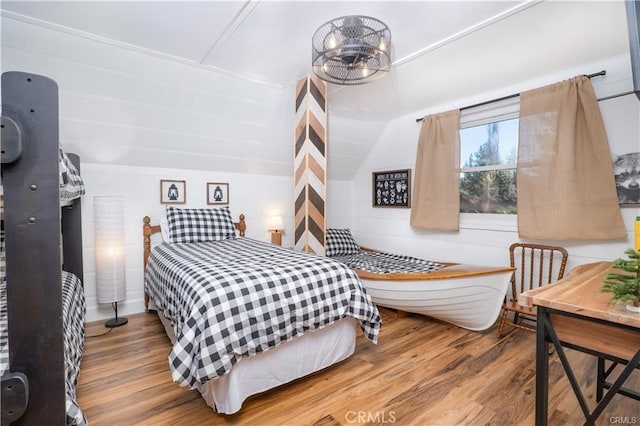 bedroom featuring a notable chandelier and wood finished floors