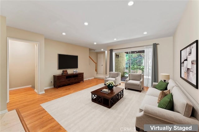 living area with stairway, recessed lighting, baseboards, and light wood-style floors