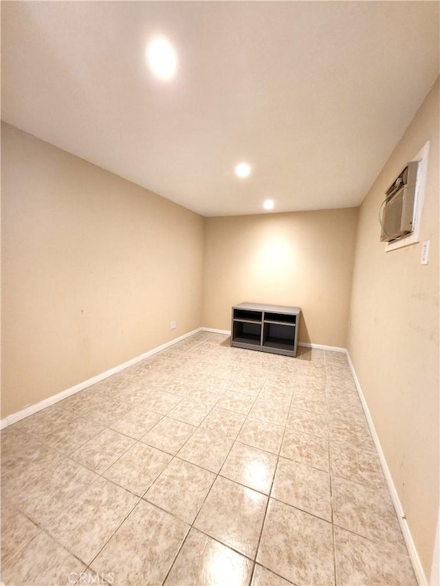 finished basement with light tile patterned flooring, recessed lighting, a wall mounted air conditioner, and baseboards