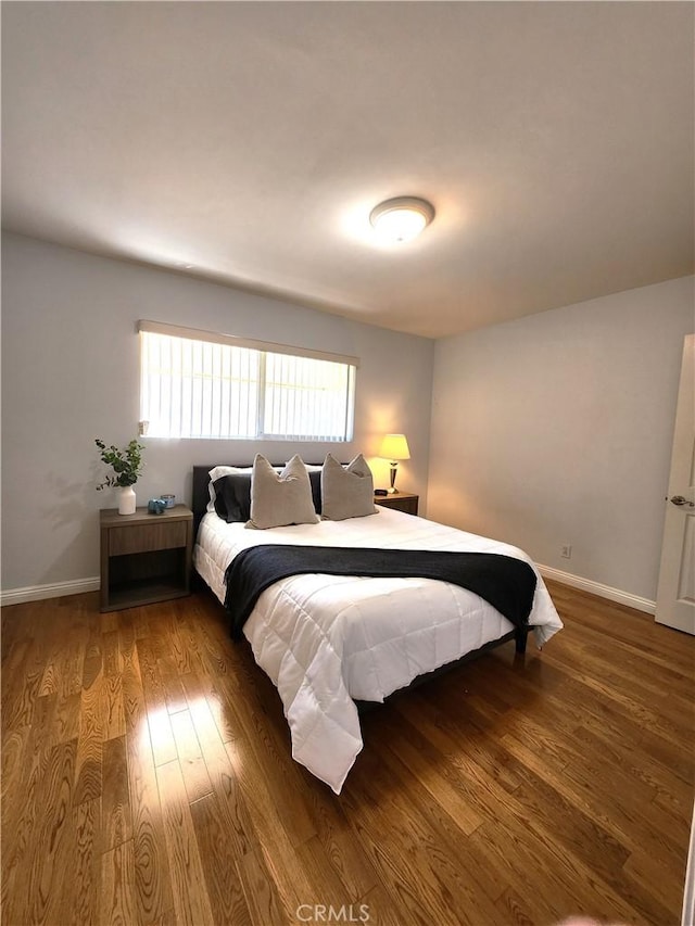 bedroom featuring baseboards and wood finished floors