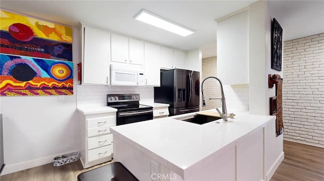 kitchen with white microwave, stainless steel electric stove, light countertops, and black fridge