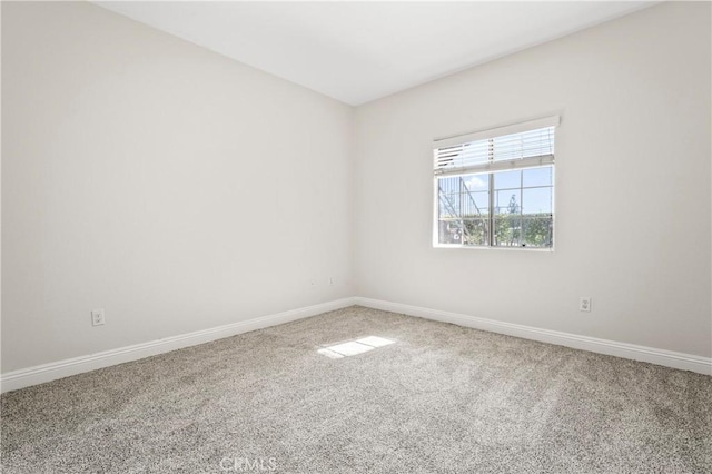 empty room featuring carpet floors and baseboards