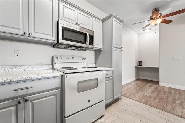 kitchen with white electric stove, gray cabinetry, a ceiling fan, light wood-style floors, and stainless steel microwave