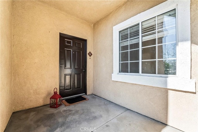 entrance to property featuring stucco siding