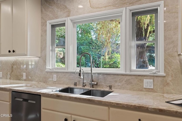 kitchen featuring decorative backsplash, a healthy amount of sunlight, a sink, and stainless steel dishwasher