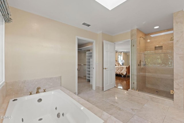 bathroom with ensuite bathroom, a skylight, visible vents, a jetted tub, and a stall shower