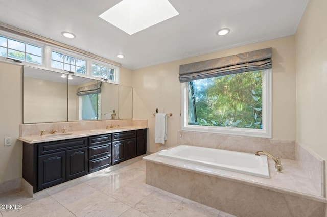 full bath featuring a skylight, a sink, a bath, and a healthy amount of sunlight