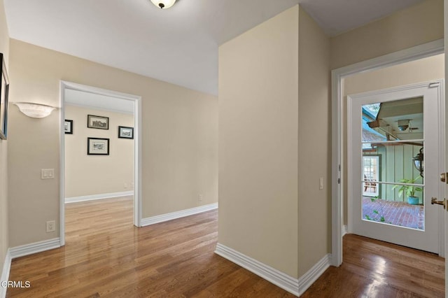 hallway with baseboards and wood finished floors