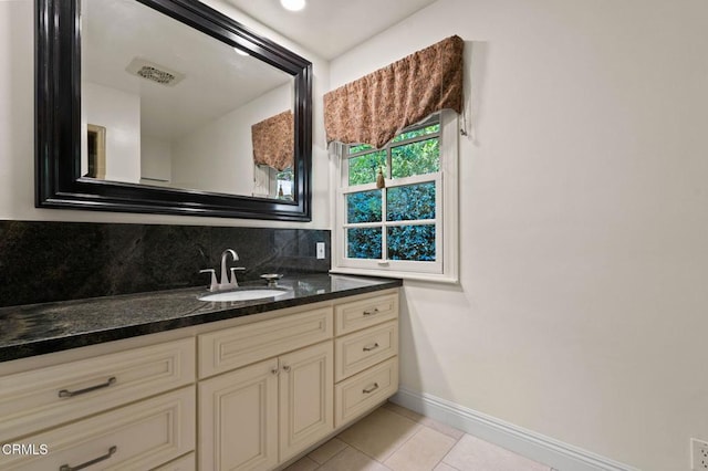 bathroom featuring tile patterned flooring, baseboards, backsplash, and vanity