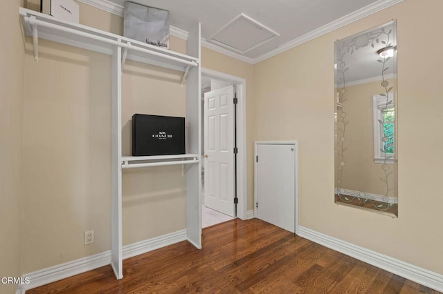 unfurnished bedroom featuring attic access, ornamental molding, baseboards, and wood finished floors