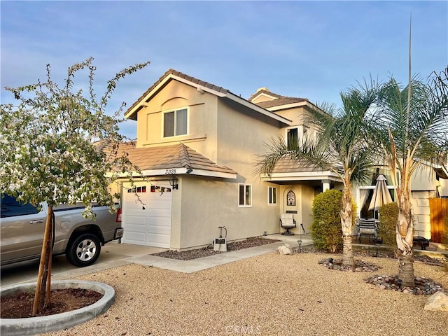 view of front of house with driveway, a tiled roof, and stucco siding