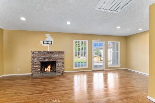 unfurnished living room featuring light wood-style floors, a fireplace, and baseboards