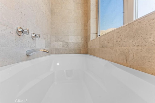 full bathroom featuring tile walls and a bath