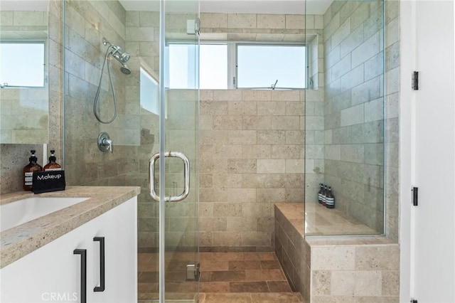 bathroom featuring a healthy amount of sunlight, a stall shower, and vanity