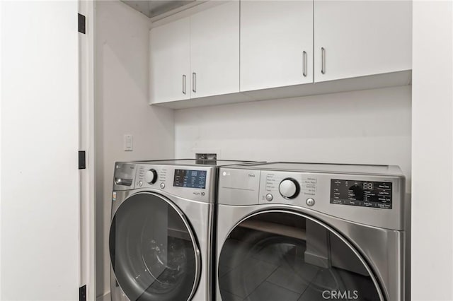 washroom featuring cabinet space and washing machine and clothes dryer