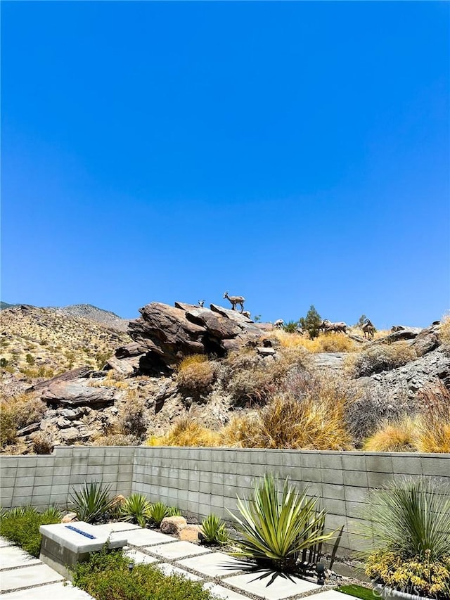 view of yard featuring fence and a mountain view