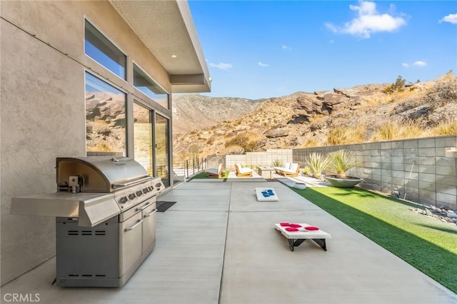 view of patio / terrace featuring a grill, a fenced backyard, a mountain view, and area for grilling