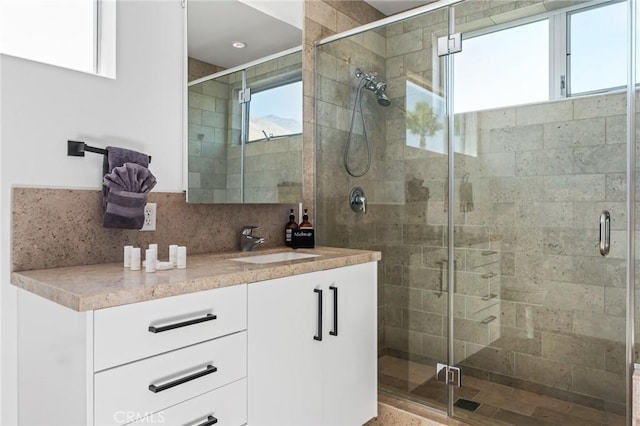 bathroom featuring a stall shower, vanity, and decorative backsplash