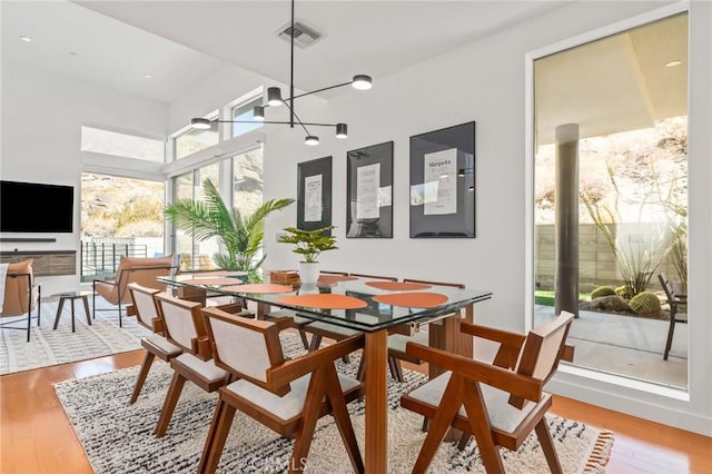 dining room featuring visible vents, a chandelier, and wood finished floors