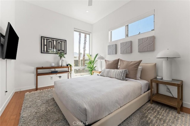 bedroom with a ceiling fan, baseboards, and wood finished floors