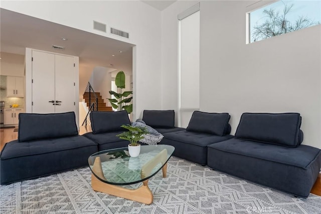 living room featuring stairs and visible vents