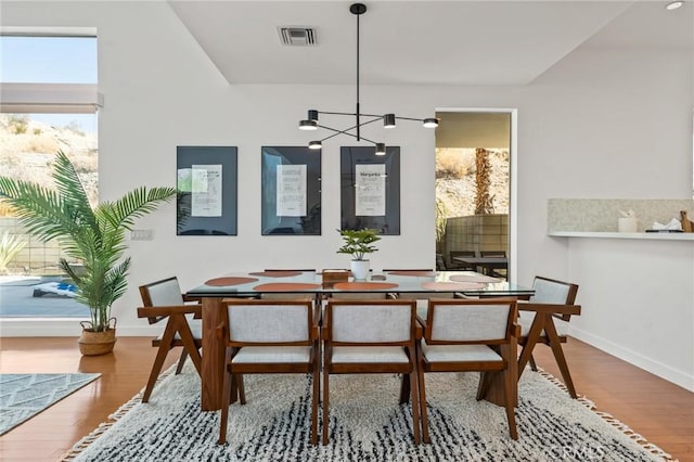 dining room featuring visible vents, baseboards, and wood finished floors