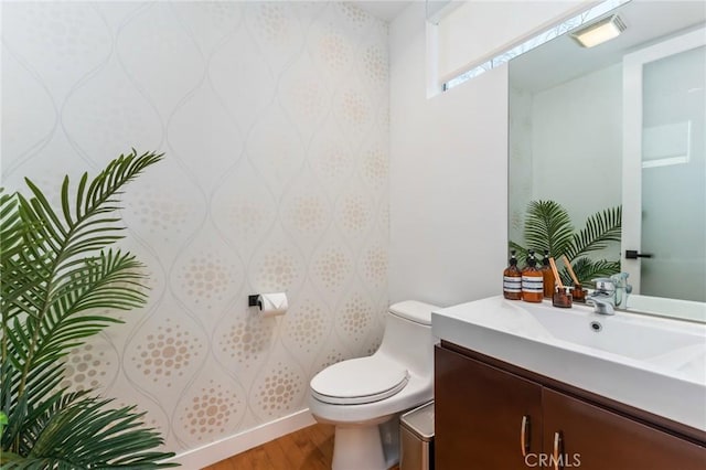 bathroom featuring toilet, visible vents, wood finished floors, and vanity