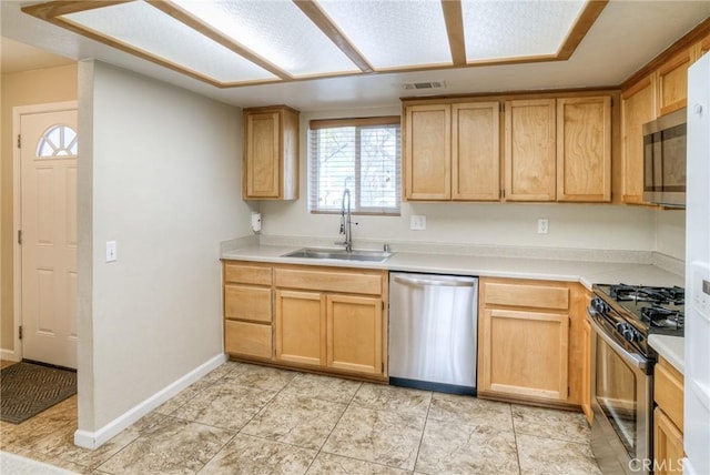 kitchen featuring stainless steel appliances, light countertops, visible vents, a sink, and baseboards