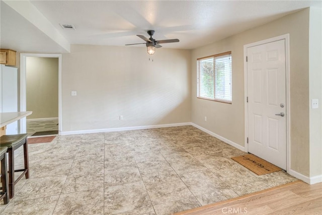 interior space with a ceiling fan, visible vents, and baseboards